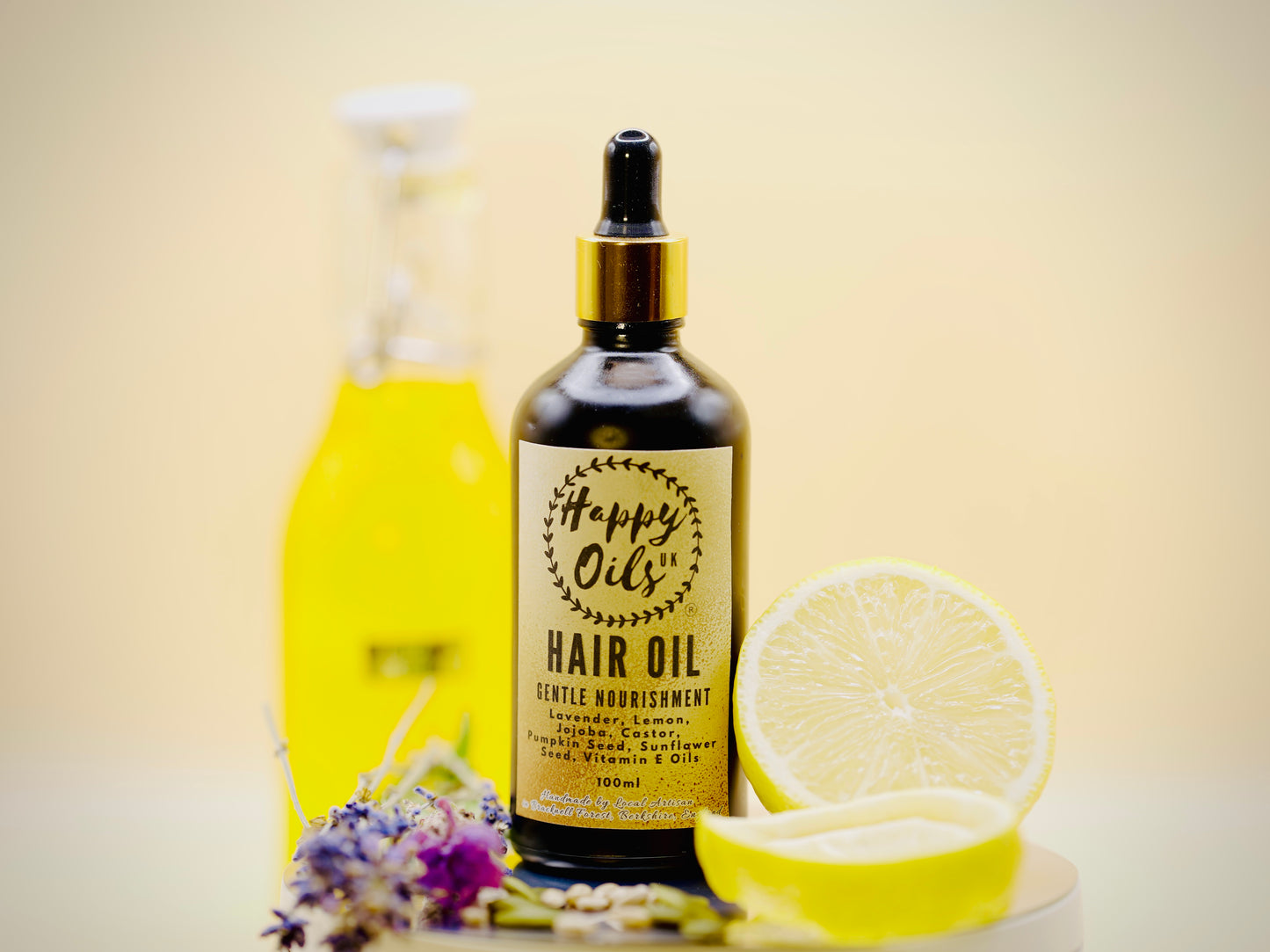 Hair oil bottle with lemon and flowers on a light background