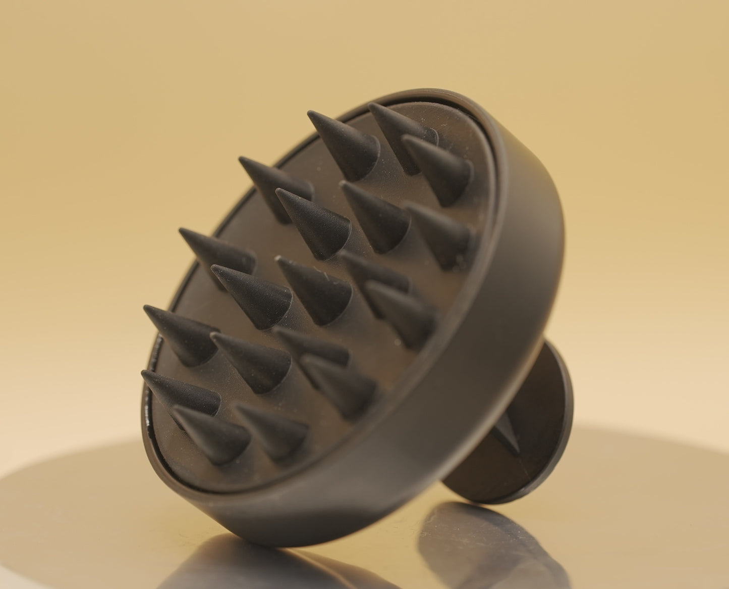 Black scalp massager on a beige background