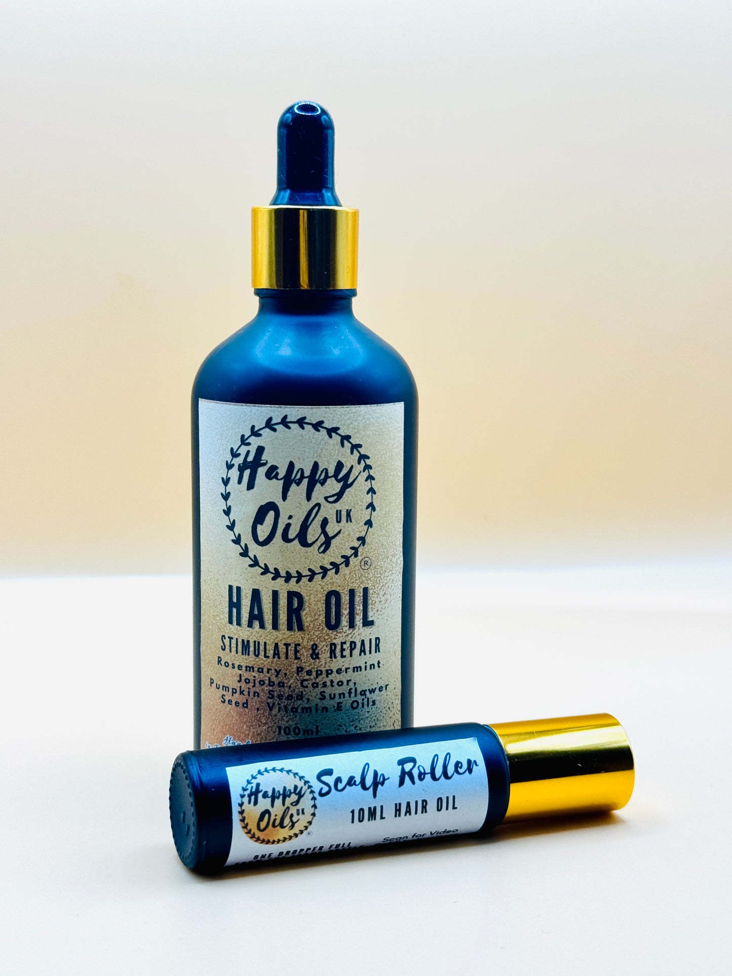Happy Oils hair oil bottle and roller on a white background